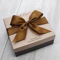 A closed 24 piece assortment. The brown box features a brown ribbon on it.